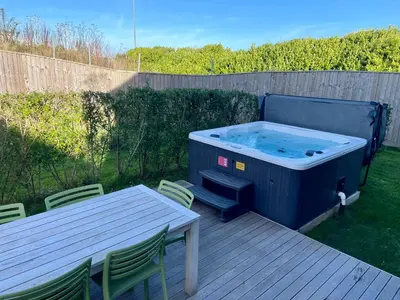 a hot tub on a deck with a table and chairs at Una, Lodge 73 in St Ives