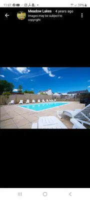 a picture of a swimming pool with chairs and a website at Hot Tub Lodge Cornwall in St Austell