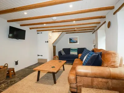 a living room with a couch and a table at Crab Cottage in Delabole