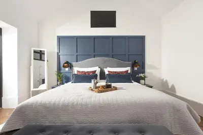 a bedroom with a large bed with a large headboard at Trebyre in Padstow