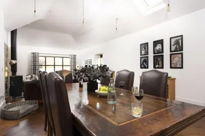 a dining room with a wooden table and chairs at Trebyre in Padstow