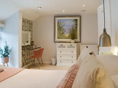 a bedroom with a bed and a dresser and a mirror at Crew Quarters in Fowey