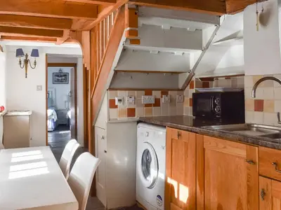a kitchen with a washing machine and a sink at Harbour Studio in Polperro
