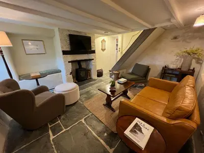 a living room filled with furniture and a fireplace at Rosebank Cottage in Boscastle