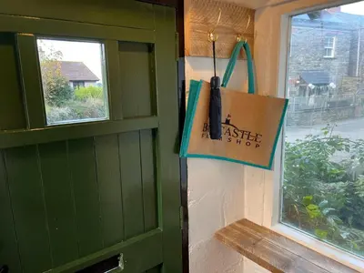 a green door with a bag next to a window at Rosebank Cottage in Boscastle