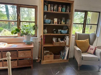a room with a desk and a chair and a book shelf at The Artists Studio in Saint Cleer