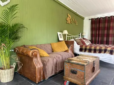 a living room with a couch and a bed at The Artists Studio in Saint Cleer