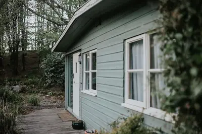 a blue house with two windows and a porch at The Artists Studio in Saint Cleer