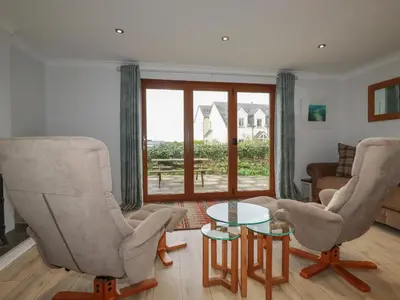 a living room with two chairs and a glass table at 3 The Bowling Green in Truro