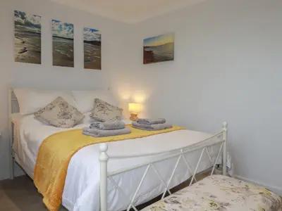 a bedroom with a white bed with a yellow blanket at 3 The Bowling Green in Truro