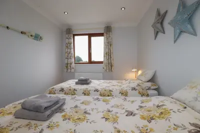 a bedroom with two beds and a window at 3 The Bowling Green in Truro