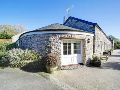 a stone building with a white door on it at Dolphin Cottage in Charlestown