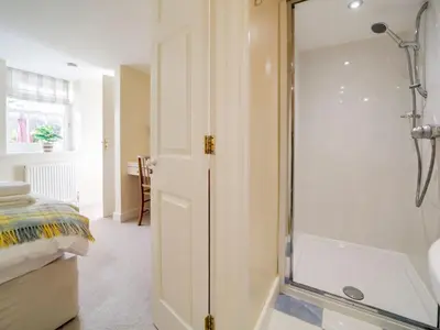 a bathroom with a shower with a glass door at Dolphin Cottage in Charlestown