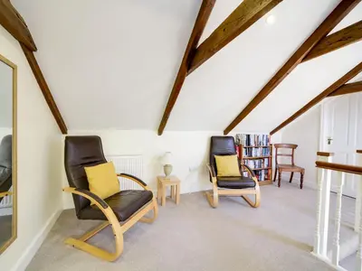 two chairs in a living room with wooden ceilings at Dolphin Cottage in Charlestown