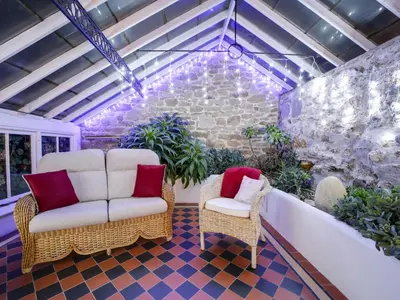 a patio with two chairs and a wall with lights at Dolphin Cottage in Charlestown
