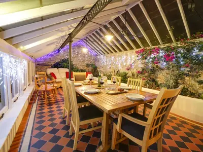 a dining room with a table and chairs on a patio at Dolphin Cottage in Charlestown