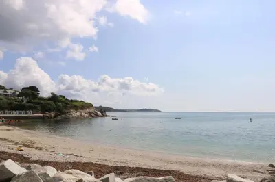 a beach with rocks and the ocean on a cloudy day at Sea Dream in Falmouth