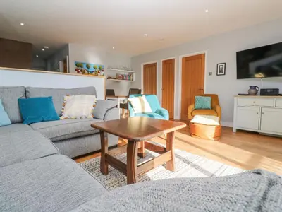 a living room with a couch and a table at Sea Dream in Falmouth