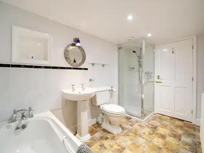 a bathroom with a toilet and a sink and a bath tub at Turtle Cottage in Charlestown