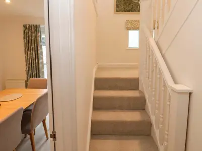 a staircase in a home with a table and a stair case at Sea View in St Ives