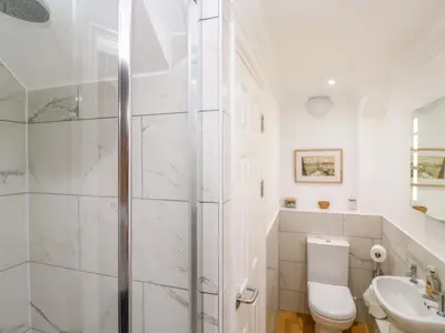a bathroom with a shower and a toilet and a sink at Sea View in St Ives