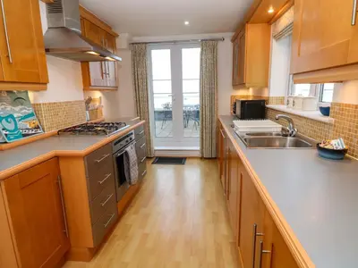a kitchen with a sink and a stove top oven at Sea View in St Ives