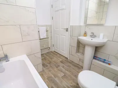 a white bathroom with a sink and a toilet at Sea View in St Ives