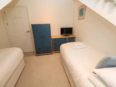 a small bedroom with two beds and a television at Sea View in St Ives