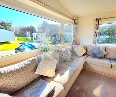 a living room with a couch and a large window at JL Cornwall Newquay Caravan in Newquay