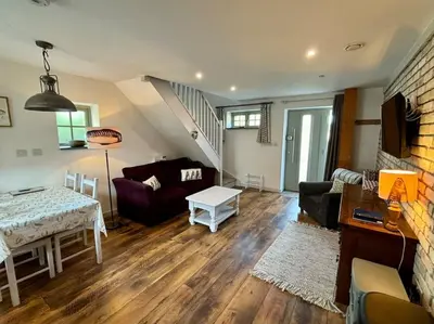 a living room with a couch and a table at Little Bream - pretty cosy cottage, sea views, walk to the beach in Mawnan Smith