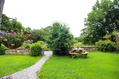 a picnic table in the grass in a garden at Coach House St Wenn in Bodmin