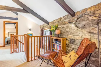 a living room with a stone wall at Coach House St Wenn in Bodmin