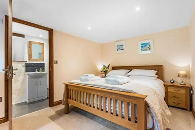 a bedroom with a large bed and a sink at Coach House St Wenn in Bodmin
