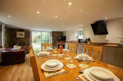 a table with plates and glasses on it in a kitchen at Coach House St Wenn in Bodmin