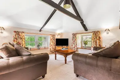 a living room with two couches and a television at Coach House St Wenn in Bodmin