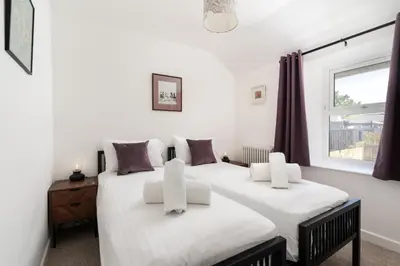 two beds in a white room with a window at Gwel Porth - St Ives - Sea Views in St Ives