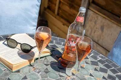 a table with two glasses and a bottle of soda at Gwel Porth - St Ives - Sea Views in St Ives