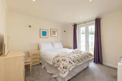 a bedroom with a large bed and a window at Newquay - Atlantic Lodge - 10 - Pets - Pools - Gym in Newquay
