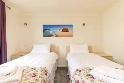 two beds sitting next to each other in a room at Newquay - Atlantic Lodge - 10 - Pets - Pools - Gym in Newquay