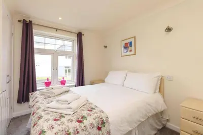 a bedroom with a white bed with towels on it at Newquay - Atlantic Lodge - 10 - Pets - Pools - Gym in Newquay