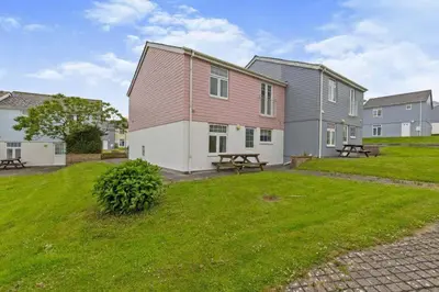 a house with a picnic table in a yard at Newquay - Atlantic Lodge - 10 - Pets - Pools - Gym in Newquay