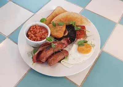 a plate of breakfast food with eggs sausage beans and toast at Newquay - Atlantic Lodge - 10 - Pets - Pools - Gym in Newquay
