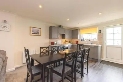 a kitchen and dining room with a table and chairs at Newquay - Atlantic Lodge - 10 - Pets - Pools - Gym in Newquay