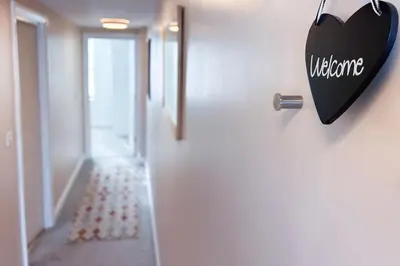 a door with a heart sign hanging on a wall at Waterside apartment, central Falmouth, Vi-spring king bed, gated parking in Falmouth