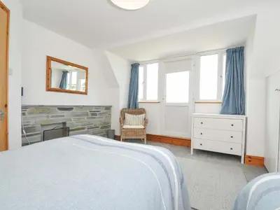 a bedroom with a bed and a fireplace at Seaworthy in Wadebridge