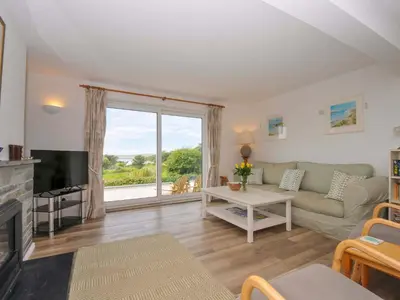 a living room with a couch and a large window at Seaworthy in Wadebridge