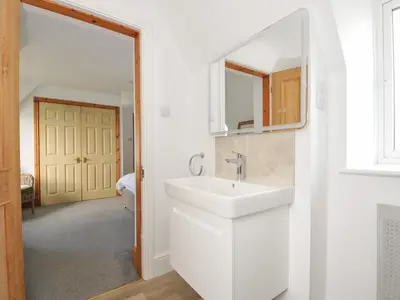 a white bathroom with a sink and a mirror at Seaworthy in Wadebridge