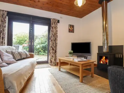 a living room with a couch and a fireplace at Court Cottage in Looe
