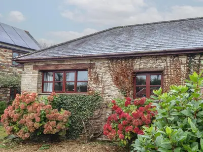 a stone house with flowers in front of it at Court Cottage in Looe