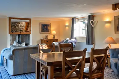 a living room with a table and a couch at Finest Retreats - Trennal Barn in Germoe